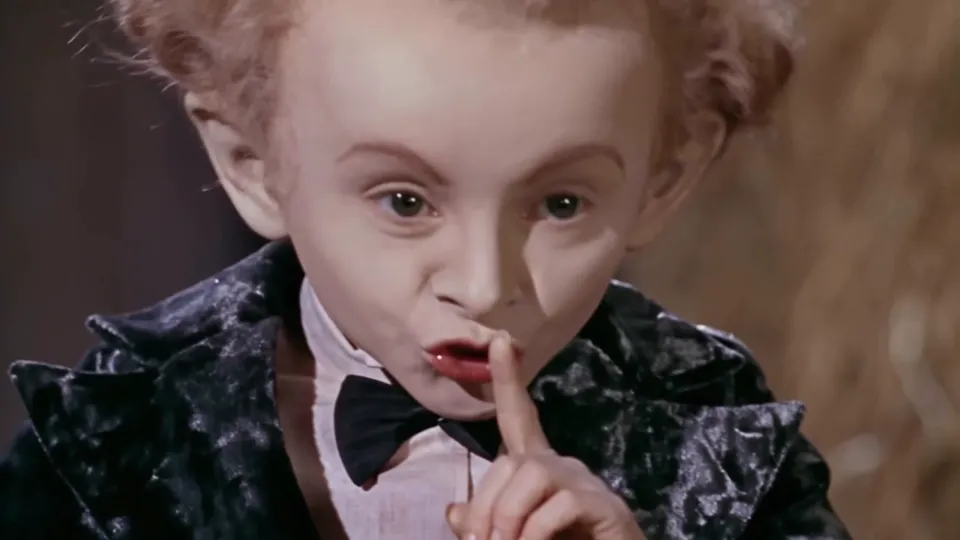 Rumpelstiltskin AI clip close-up: the dancer shushes the camera with a finger to the lips